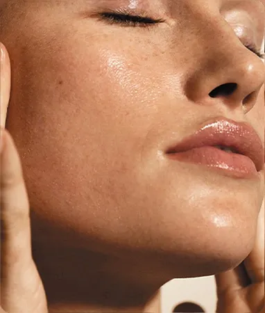 Primer plano de piel luminosa e hidratada de una mujer con los ojos cerrados